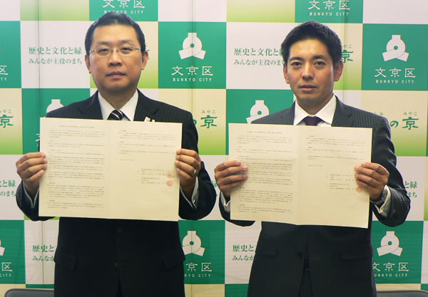 調印書を手にする成澤区長（左）と後藤副社長